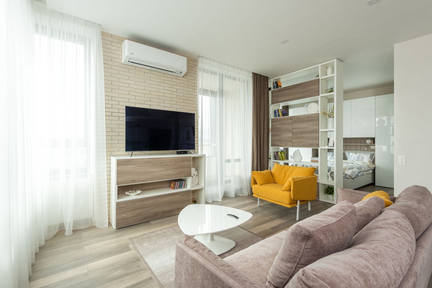 Open woonkamer met lichte muren en een gele fauteuil